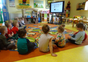 Dzieci oglądają na ekranie mobilnym bajkę edukacyjną.